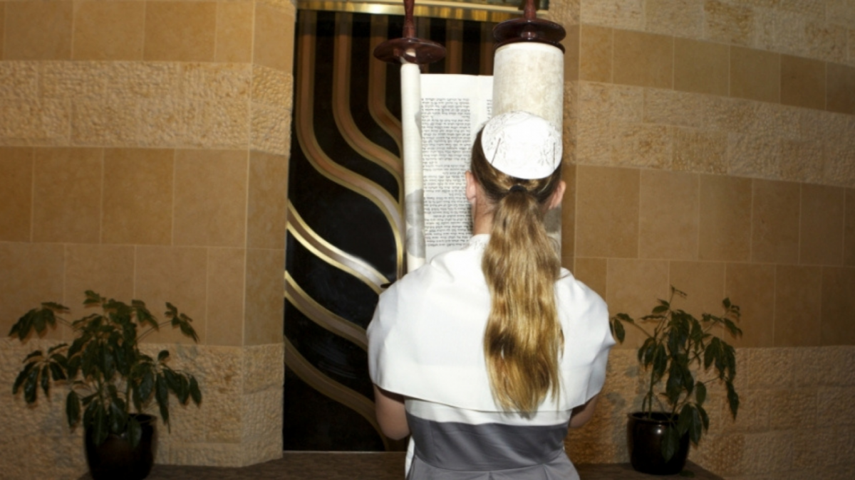 A girl on her bat mitzvah holding the Torah