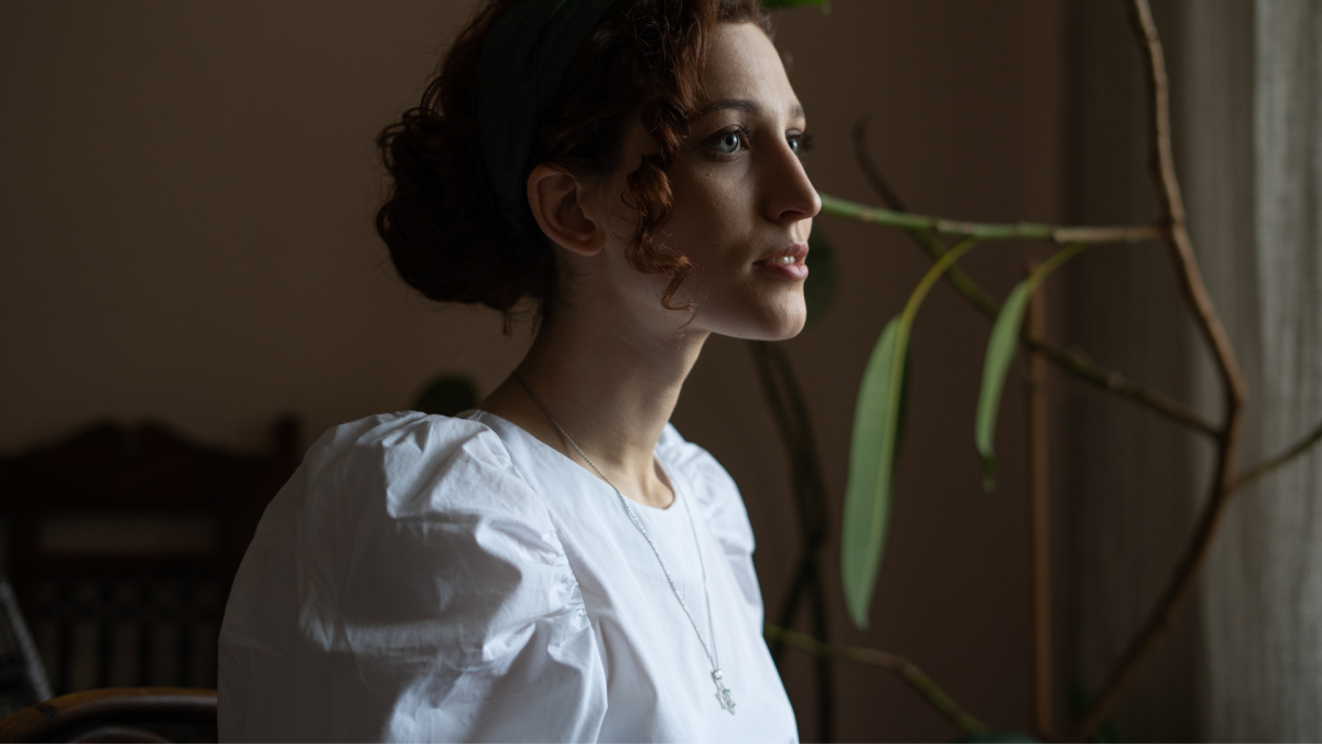 young woman with curly hair wearing a Star of David necklace