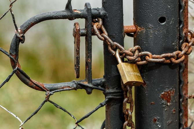 gate chained shut with rusted padlock