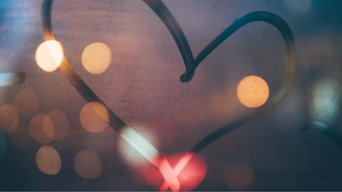 A heart shape created from fog on a window at night