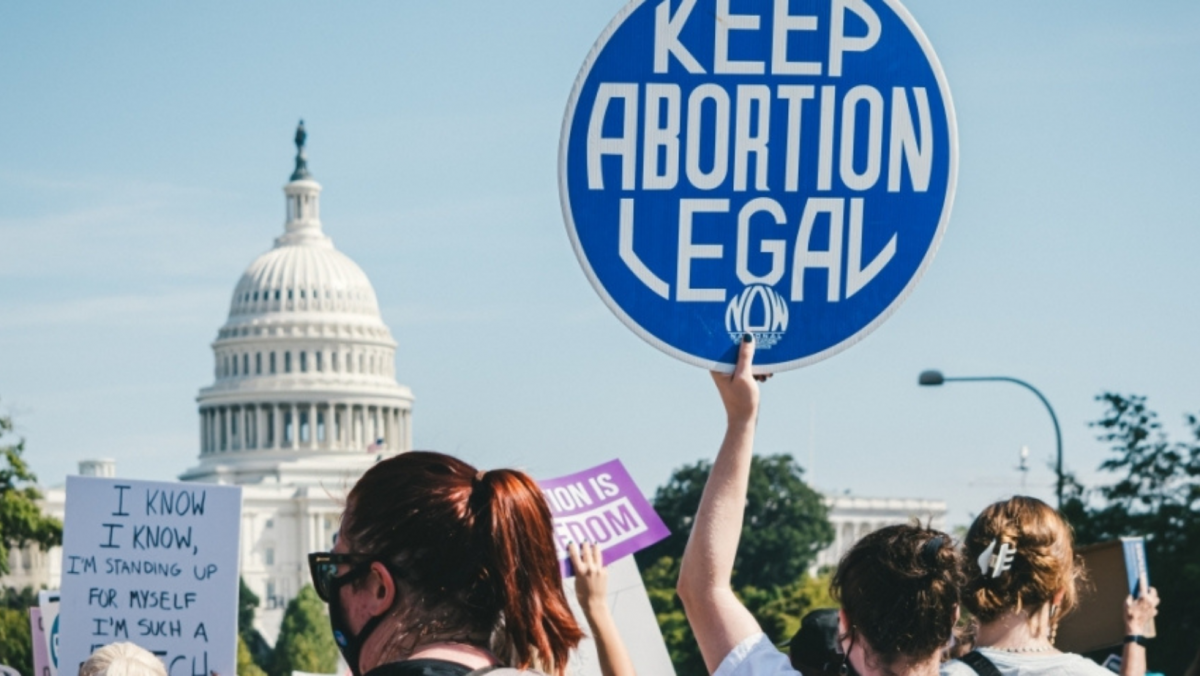 Pro-choice protestors in front of the U.S. capital building, one holding a sign saying "Keep Abortion Legal"