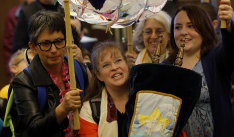 Celebratory crown marching with Torah scroll