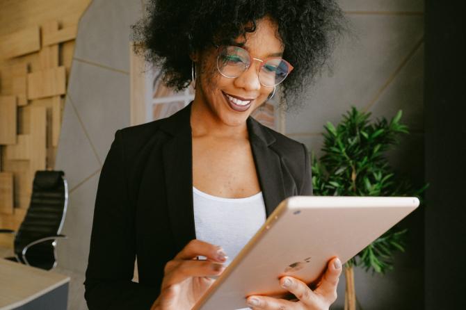 standing woman reading from iPad screen