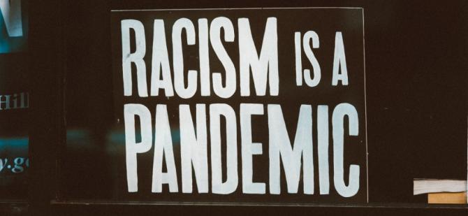 Sign reading "Racism is a Pandemic"