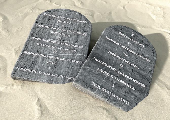 tablets of ten commandments in English on sandy ground