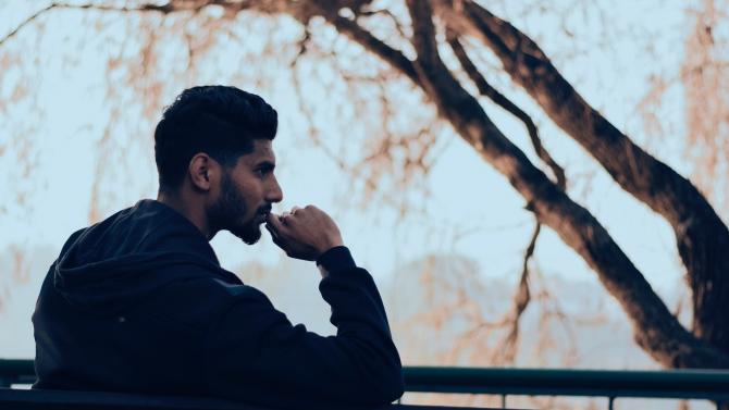 profile view of man in contemplation with trees in background