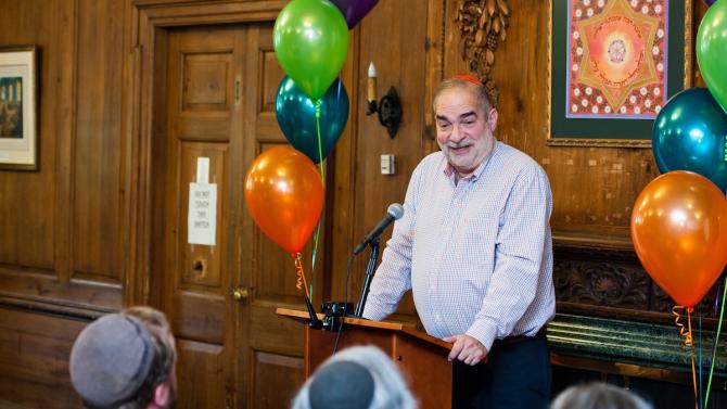 Jacob staub at podium smiling and surrounded by balloons