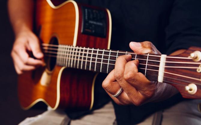 closeup of acoustic guitar being played by musician