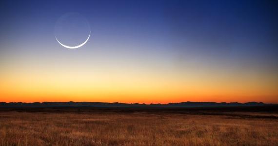 crescent moon in sky near sunset