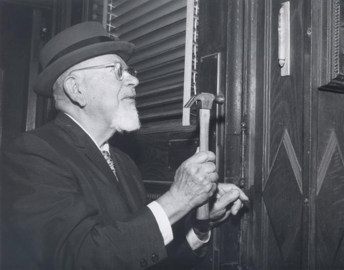 Mordecai M. Kaplan affixing a mezuzah to the doorpost of the RRC campus at Broad Street during the dedication ceremony of the college, October 13, 1968.