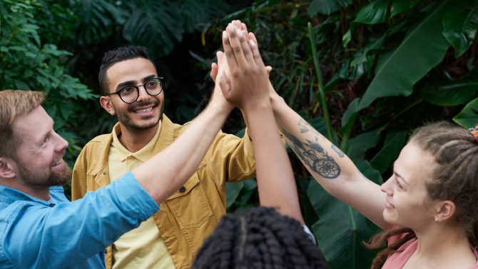 A multicultural group of people with their hands together