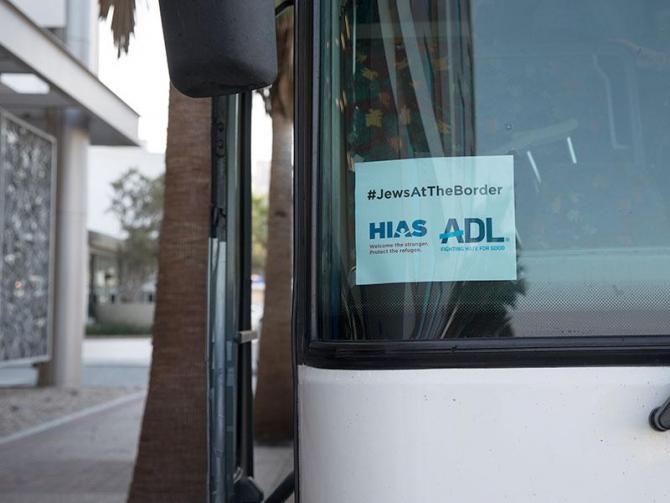 HIAS-ADL bus with a hashtag Jews at the Border sign in the window