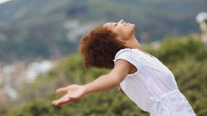 woman with head up and arms outstretched