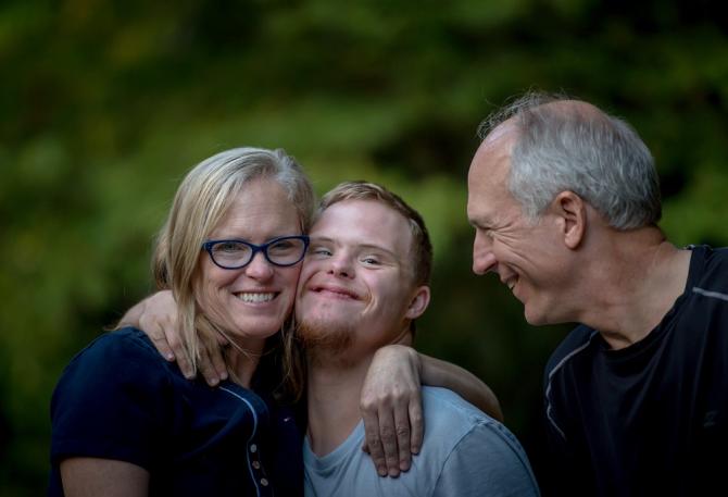 Parents and adult child embracing