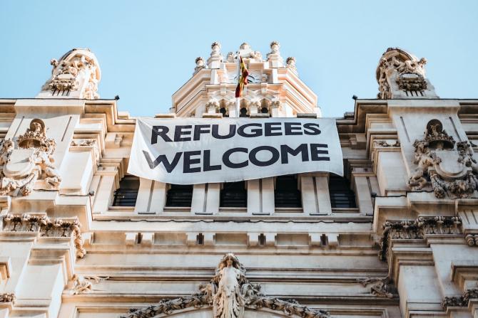 marble building hung with "refugees welcome" banner