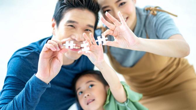 young family holding puzzle pieces