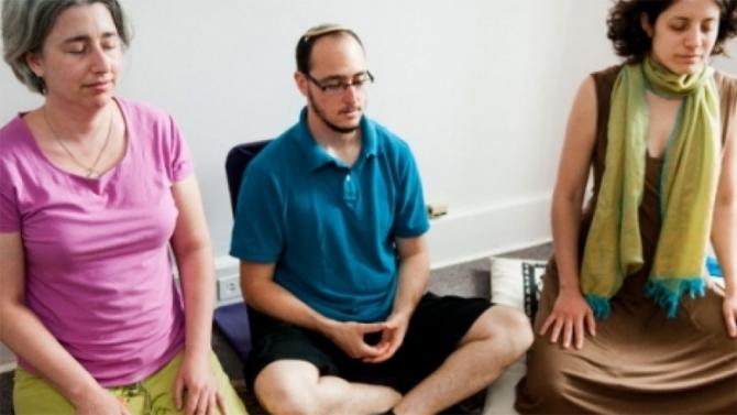 Three Jewish people sitting down with eyes closed