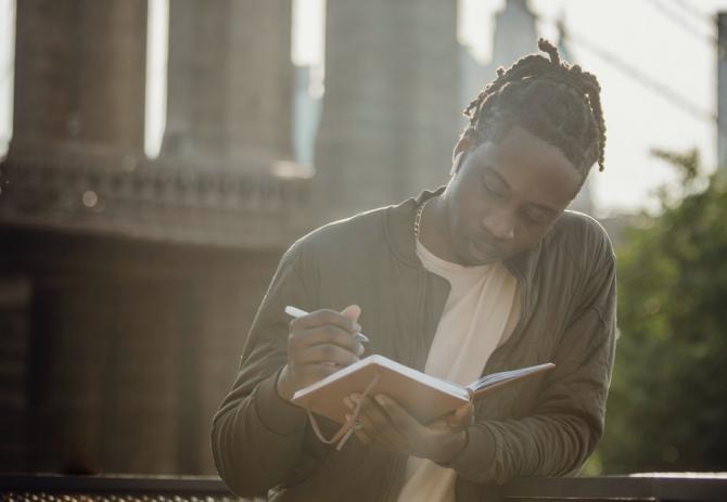 man writing in journal