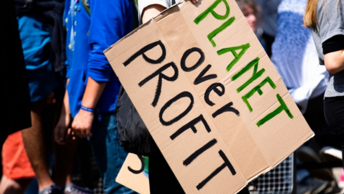 Climate protest sign that reads Planet Over Profit
