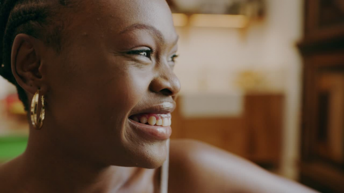 Black woman wearing gold earrings smiling