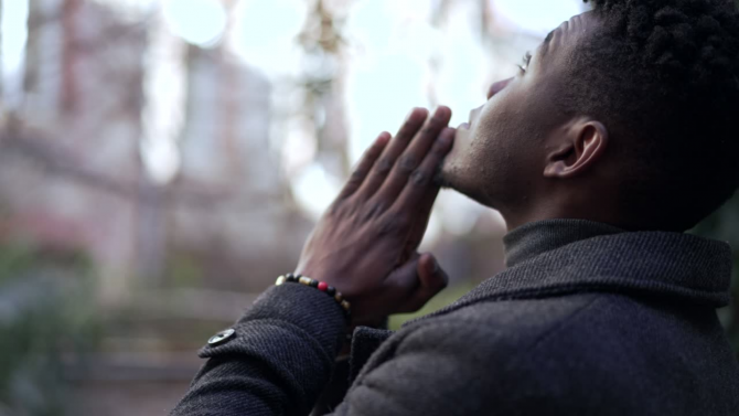 Black man looking at the sky and praying