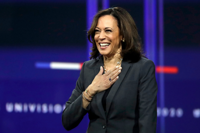 Kamala Harris smiling and holding her hand over her heart