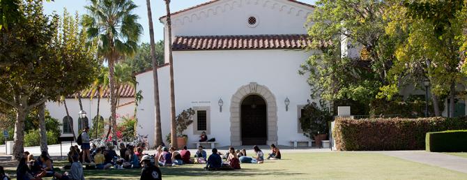 College campus building surrounded by greenery and palm trees