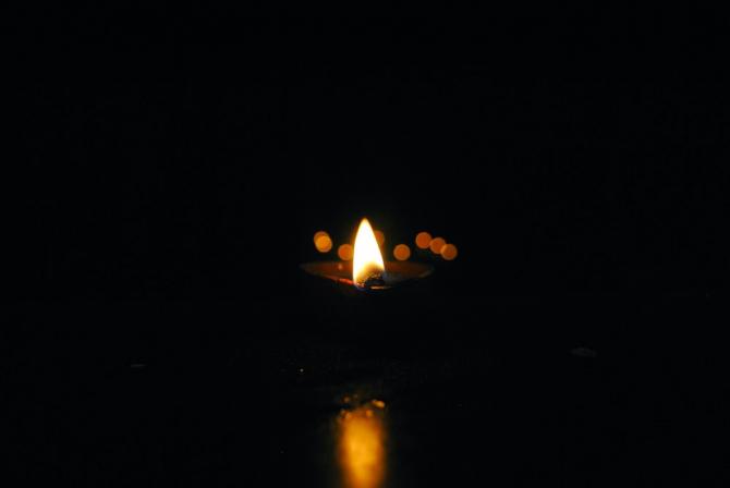 Candle burning in darkness