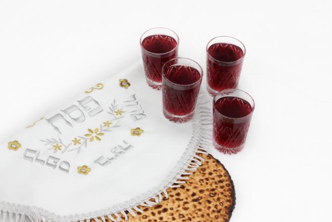 Four cups of wine next to matzah