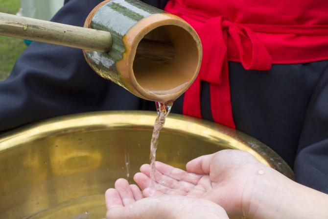 hands under water pouring pitcher