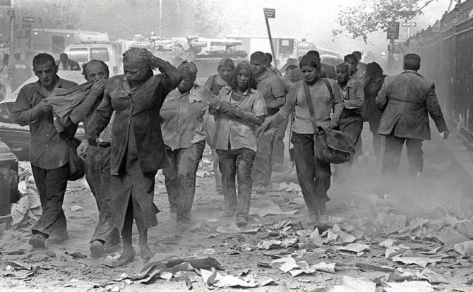 Survivors of the World Trade Center collapse walk through the streets of New York covered in dust, ash and debris