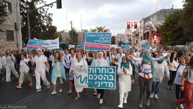 Israeli Jewish and Arab women marching for peace with placards on city street