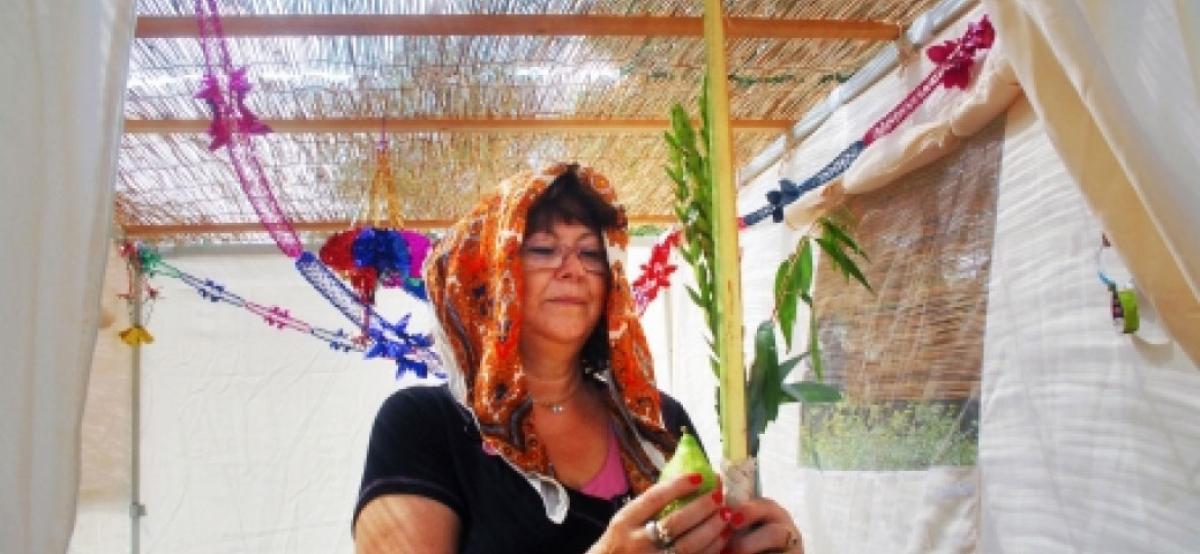 woman holding lulav and etrog for sukkot