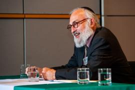 Rabbi David Teutsch seated on stage at ethics conference