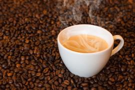 Coffee mug resting on coffee beans