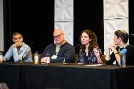 Four panel members seated on podium