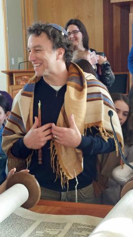Rabbi Joshua Boettiger in tallit in front of Torah scroll
