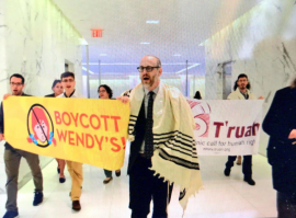 Rabbi Elliott Tepperman in tallit, marching with T'ruah members as part of Boycott Wendy's campaign
