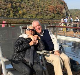 Rabbi Sheila Peltz Weinberg with husband Maynard Seider, seated with lake and mountains in the background