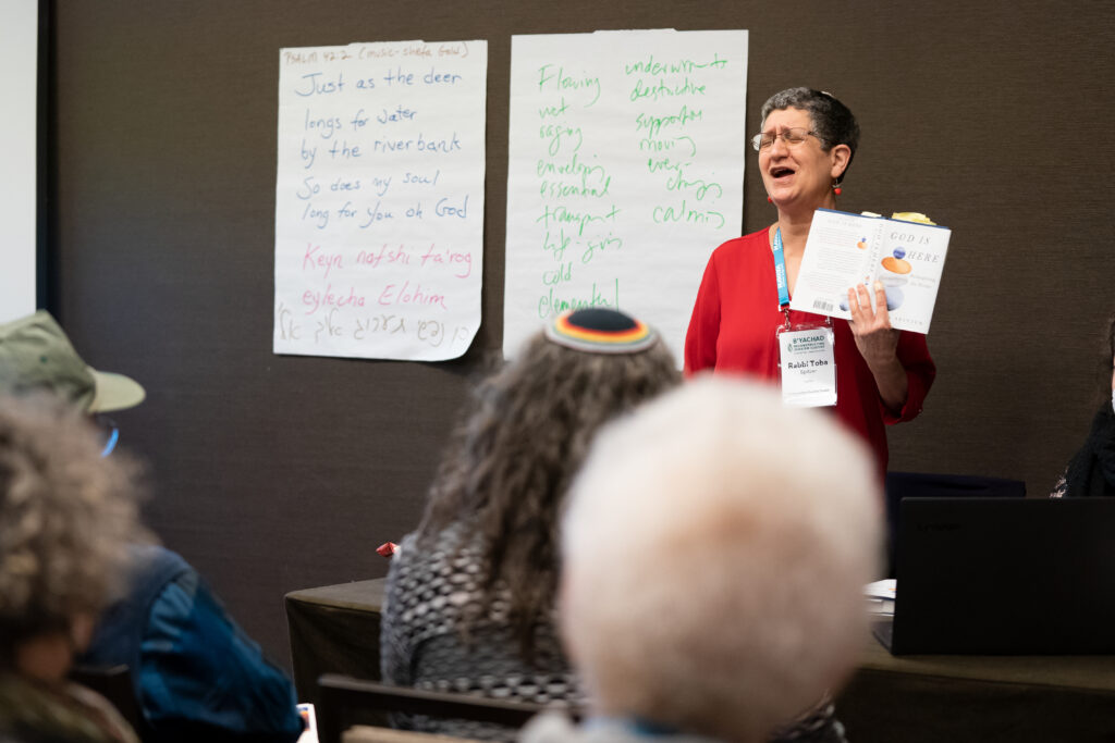Rabbi Toba Spitzer holds a copy of her book while teaching a class.