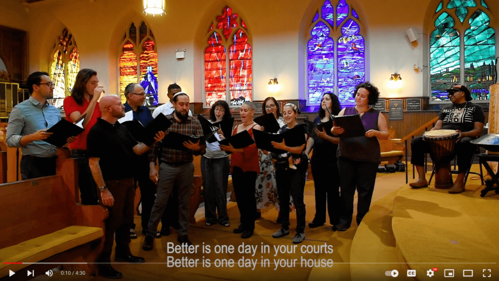 Participants of the Spontaneous Philadelphia Interfaith Choral Ensemble singing inside a synagogue