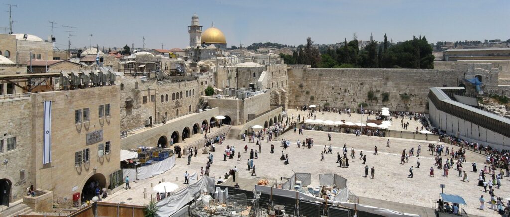 An overview of the Western Wall Plaza in Jerusalem with the Dome of the Rock in the background.