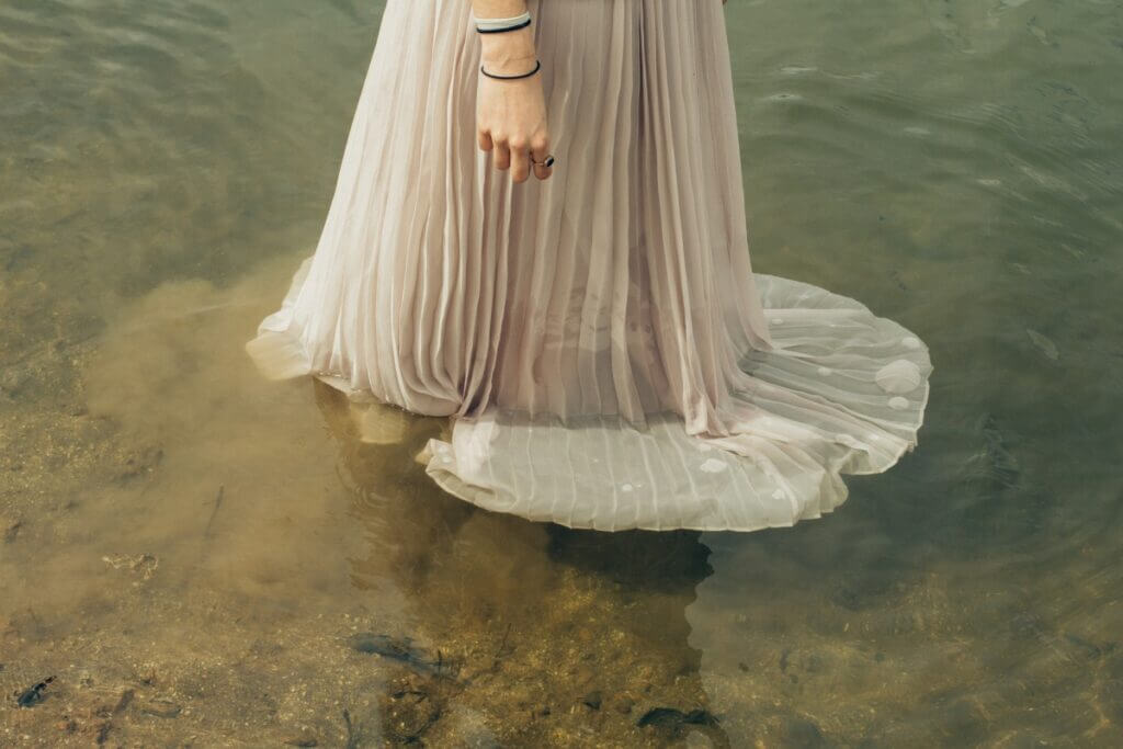 A woman in a dress standing in a shallow lake