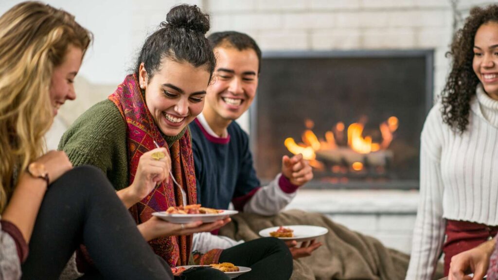 People eating in front of a fireplace