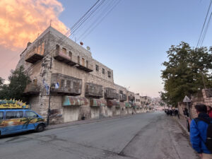 A streetscape scene in Hebrew.