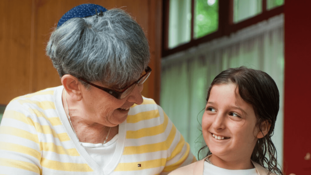 A young girl with an older woman wearing a kippah