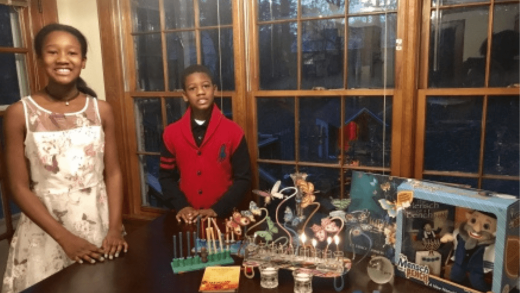 A young Black family celebrating Kwanzaa and Hanukkah