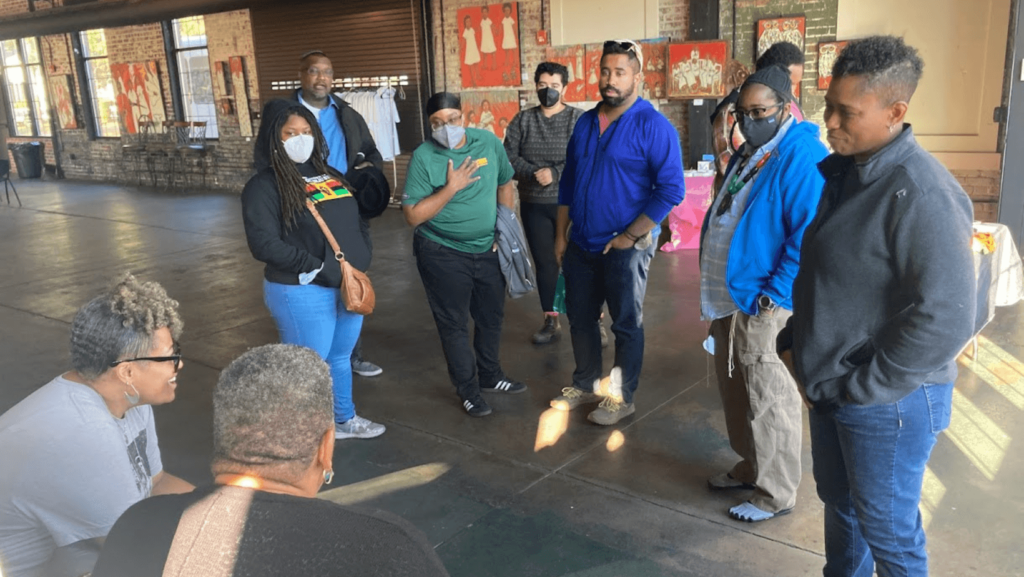 A group of Black people talking in an art gallery