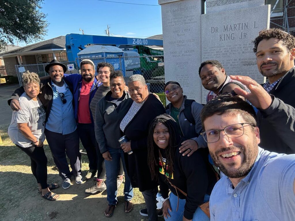 A group of Jews of African descent gather in Selma, Ala. with activist Joanne Bland. They are in front of the Brown Chapel AME Church, an important organizing center.Rabbi Micah Weiss is the only white person in the picture and is wearing teffilin.