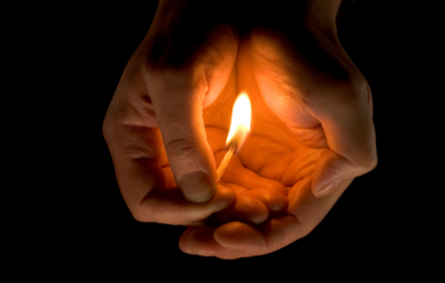 lit match being held near hands